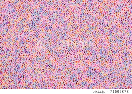 Pastel color balls texture. Styrofoam or Polystyrene foam background. Mix of colorful sugar balls, used to decorate baking and sweets. Rainbow colored sugar chips or dragee spins, confectionery 71695378