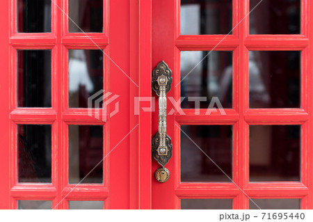 Vintage antique metal door handle on red wooden door Vintage antique metal door handle on red wooden door 71695440