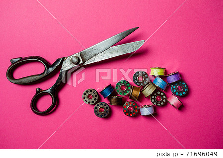 Professional tailor scissors and pile of metal bobbins Professional tailor scissors and pile of metal bobbins 71696049
