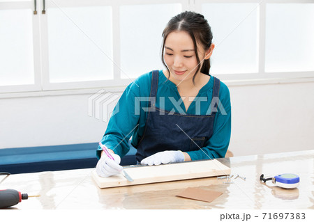 木材カットのために墨線をひくDIY女子 71697383