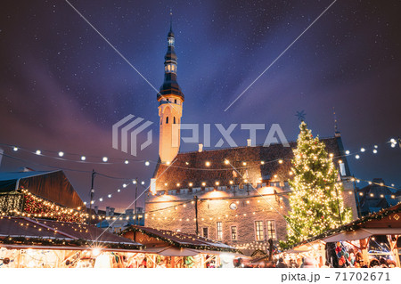 Tallinn, Estonia. Traditional Christmas Market On Town Hall Square. Christmas Tree And Trading Houses With Sale Of Christmas Gifts. Night Starry Sky Above Famous Landmark. Altered Night Sky 71702671