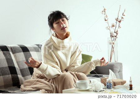 Woman wrapped in a plaid looks sick, ill, sneezing and coughing sitting at home indoors Woman wrapped in a plaid looks sick, ill, sneezing and coughing sitting at home indoors 71703020