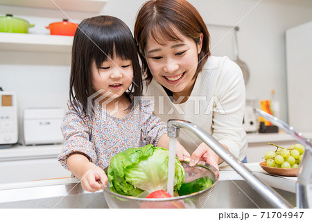 キッチンでお手伝いをする小さな女の子 キッチンでお手伝いをする小さな女の子 71704947