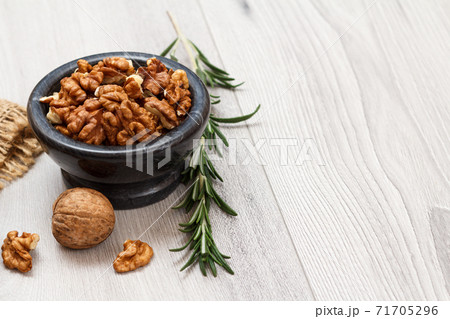 Walnuts in stone bowl on a wooden background. Walnuts in stone bowl on a wooden background. 71705296