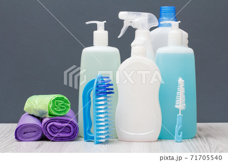 Bottles of dishwashing liquid, brushes and garbage bags on gray background. Bottles of dishwashing liquid, brushes and garbage bags on gray background. 71705540