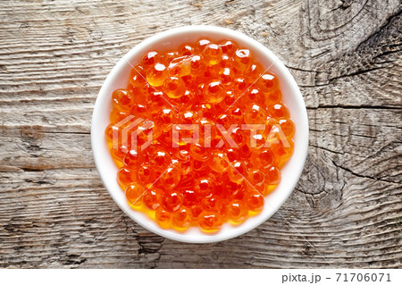 Bowl of red caviar on wood, from above Bowl of red caviar on wood, from above 71706071
