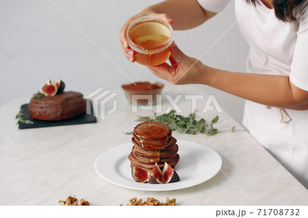Cook pours honey on the pancakes. Cook pours honey on the pancakes. 71708732