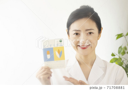 笑顔でお薬手帳を持つ女性薬剤師 71708881