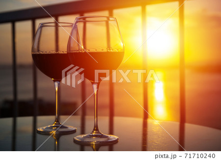 Two glasses with red wine in sunset 71710240