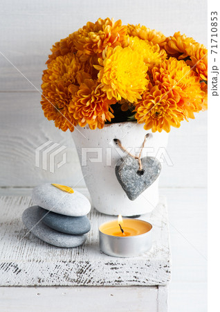 Orange chrysanthemum flowers with pebbles Orange chrysanthemum flowers with pebbles 71710853