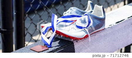 Runners spiked shoes on steeplechase barrier with a winners medal 71712746