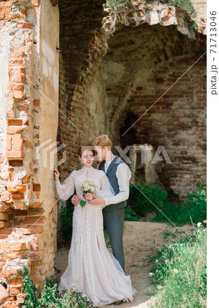 Nice redhead young just married happy couple kissing in the sunset outdoors Nice redhead young just married happy couple kissing in the sunset outdoors 71713046