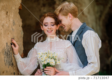 Nice redhead young just married happy couple kissing in the sunset outdoors 71713047