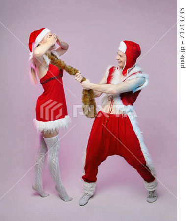 guy and girl in Santa Claus costumes. photo session in the Studio. Christmas and New year concept 71713735