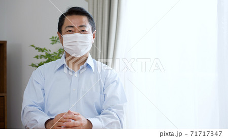 マスクを付ける中年男性 マスクを付ける中年男性 71717347