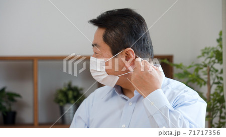 マスクを付ける中年男性 マスクを付ける中年男性 71717356