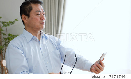スマートフォンを使う老眼の中年男性 71717444