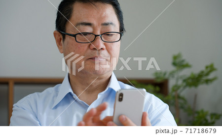 スマートフォンを使う老眼の中年男性	 71718679