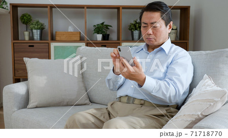 携帯電話を使う中年男性 71718770