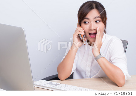 Asian woman telling secret in the office Asian woman telling secret in the office 71719351