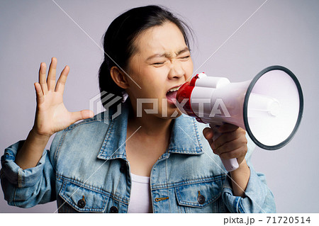 Asian woman shouting with megaphone isolated over white background. Asian woman shouting with megaphone isolated over white background. 71720514
