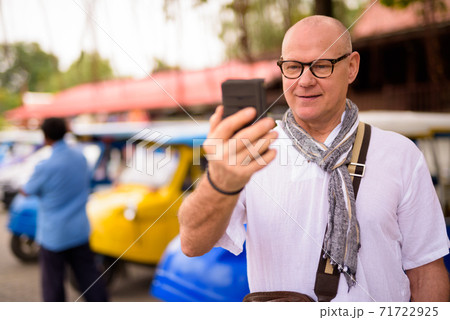 Portrait of happy senior tourist man using phone in Ayutthaya Portrait of happy senior tourist man using phone in Ayutthaya 71722925