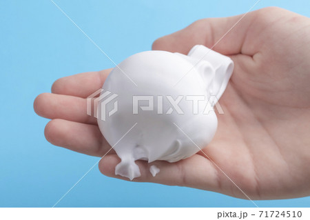 White shaving foam in the hand of a teenager on a bright colorful background. The concept of growing children and adolescents, the use of modern hygiene products 71724510