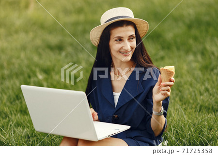 Woman in a summer park with a laptop Woman in a summer park with a laptop 71725358