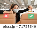 Young Woman in a protective mask point her finger to the right green sign to support social distancing 71725649