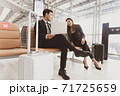 A passenger businessman and woman talking with happy while waiting on boarding at the airport with luggage nearby, lifestyle business people. 71725659