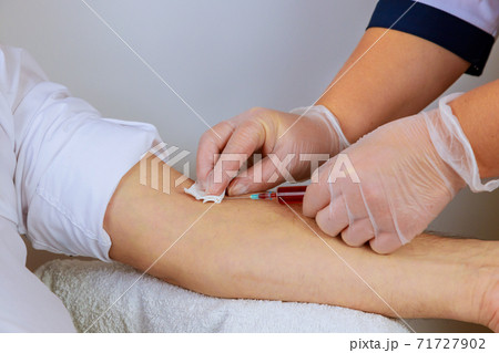 A nurse use a syringe to take a blood sample from a man to be tested for HIV AIDS 71727902