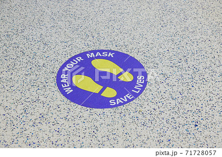 Inscription on the floor at the airport wear your mask save lives 71728057