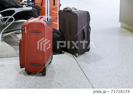 Travelers with suitcases through the airport in departure lounge Travelers with suitcases through the airport in departure lounge 71728179