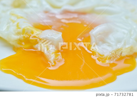 fried egg with creamy yolk flowing on plate fried egg with creamy yolk flowing on plate 71732781