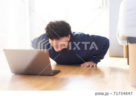 PCを見ながら運動をする若い男性 PCを見ながら運動をする若い男性 71734647