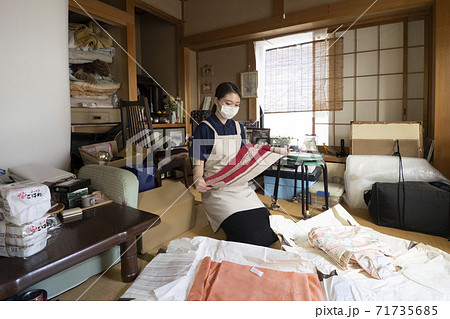 散らかった部屋を片付ける女性作業員 散らかった部屋を片付ける女性作業員 71735685