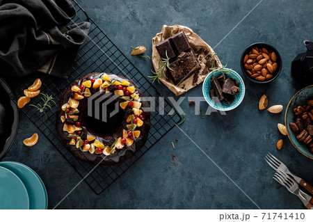 Christmas chocolate bundt cake with ganache decorated with oranges, berries and rosemary Christmas chocolate bundt cake with ganache decorated with oranges, berries and rosemary 71741410
