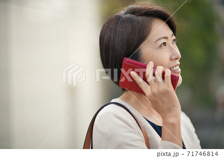 スーツを着てスマホで通話する日本人ビジネスウーマン・働く40代の女性 スーツを着てスマホで通話する日本人ビジネスウーマン・働く40代の女性 71746814
