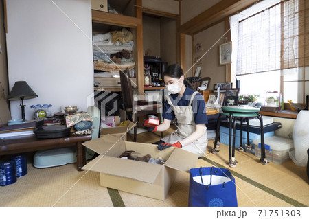 散らかった部屋を片付ける女性作業員 71751303
