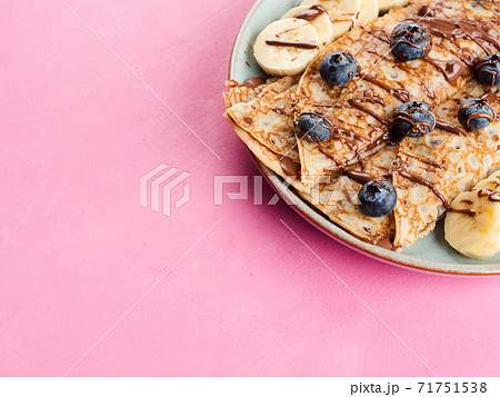 Crepes with chocolate nut spread, banana, berries 71751538