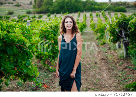 woman in green dress in the garden of grapes harvest woman in green dress in the garden of grapes harvest 71752457
