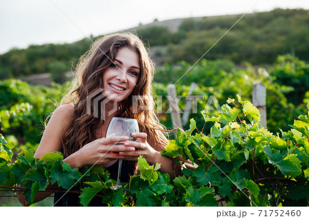 woman in green dress with a glass of wine in the garden of grapes woman in green dress with a glass of wine in the garden of grapes 71752460