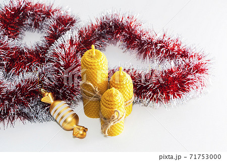 a group of wax candles tied with a rope. Natural wax. On light background. Christmas, new year. 71753000
