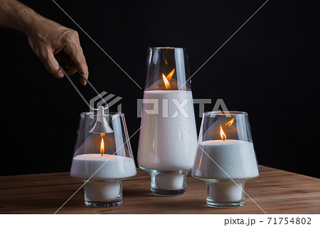 Hand extinguishes the candles. Candles smoke. Black background Hand extinguishes the candles. Candles smoke. Black background 71754802