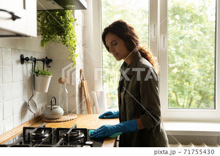 Young woman in rubber gloves clean kitchen oven Young woman in rubber gloves clean kitchen oven 71755430