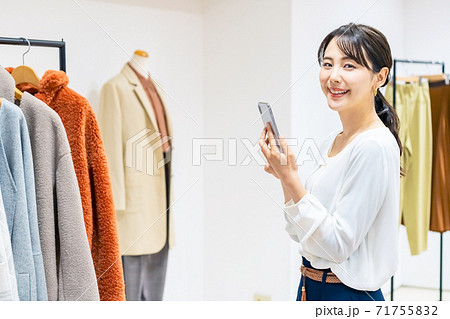 アパレルショップでスマホを使う女性 アパレルショップでスマホを使う女性 71755832