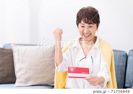 通帳を見て喜ぶ女性 71756849