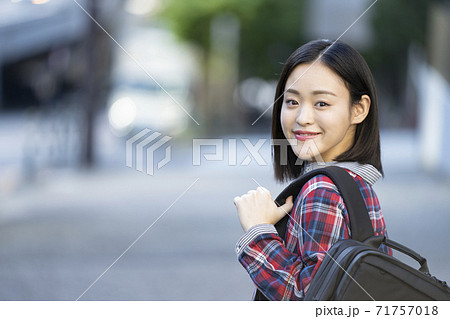 バックパックを肩にかけたカメラ目線の若い女性 バックパックを肩にかけたカメラ目線の若い女性 71757018