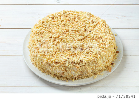 Homemade honey cake with sour cream on a white wooden table. Space for text. Homemade honey cake with sour cream on a white wooden table. Space for text. 71758541