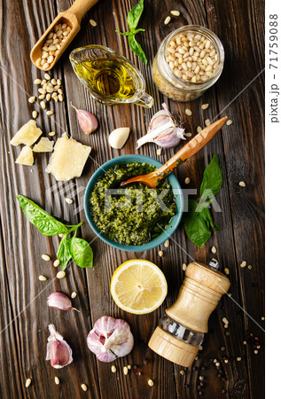 Flat lay view at food background of genovese pesto sauce and its ingredients on wooden kitchen table representing mediterranean cuisine Flat lay view at food background of genovese pesto sauce and its ingredients on wooden kitchen table representing mediterranean cuisine 71759088